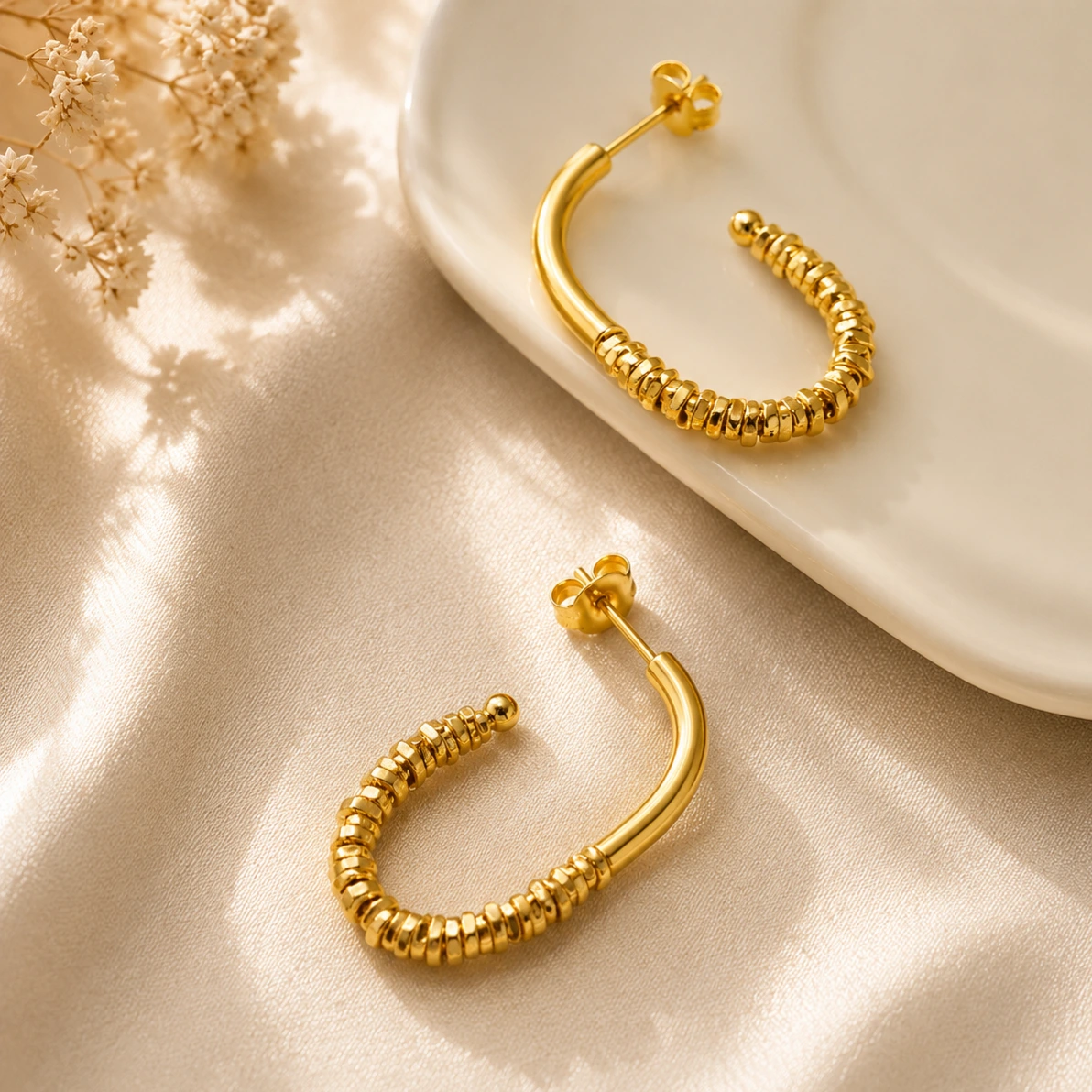 Brinco dourado meia argola com detalhe M