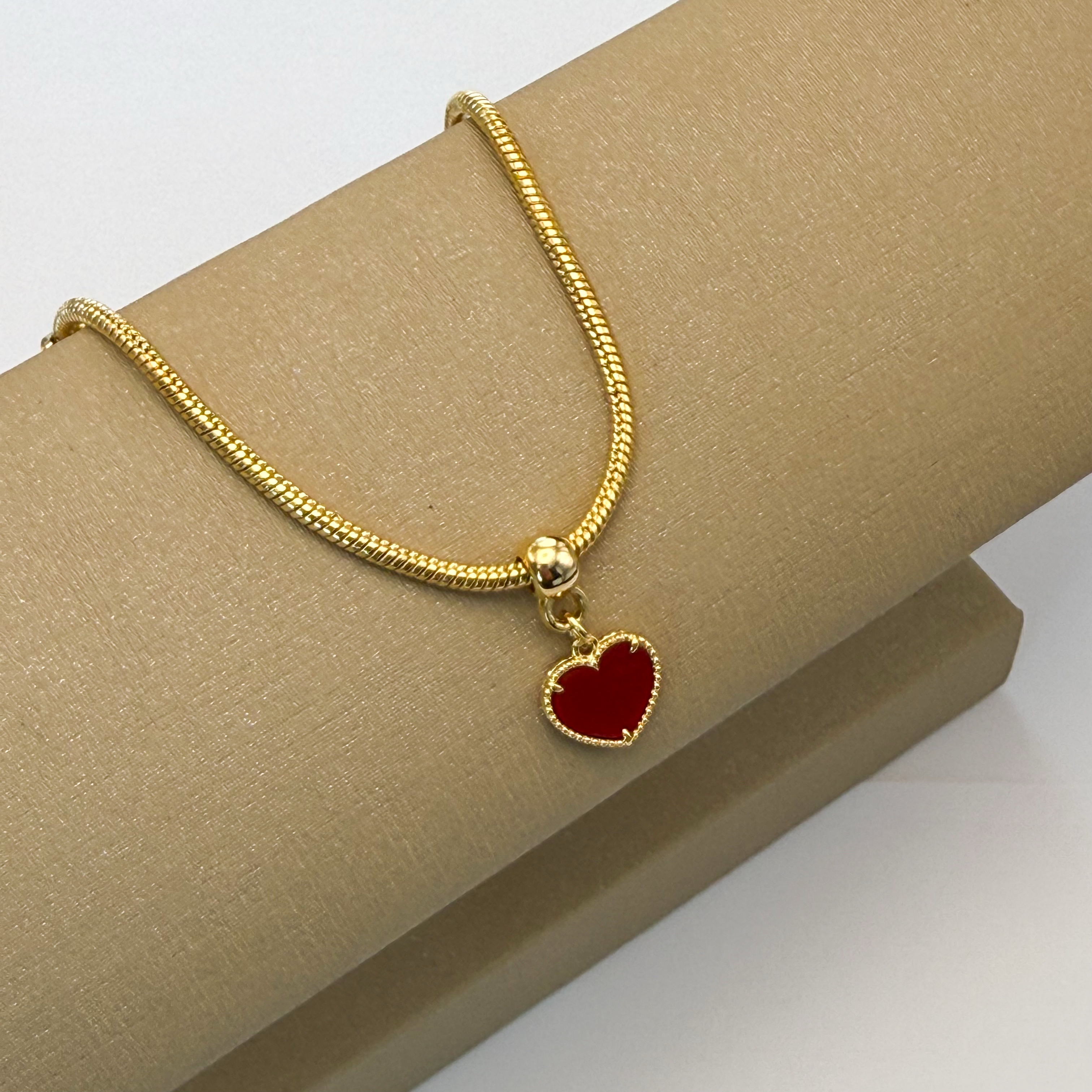 Pulseira dourada coração vermelho