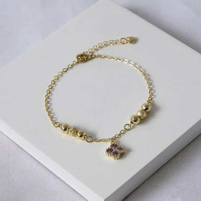 Pulseira dourada esferas e trevo ametista